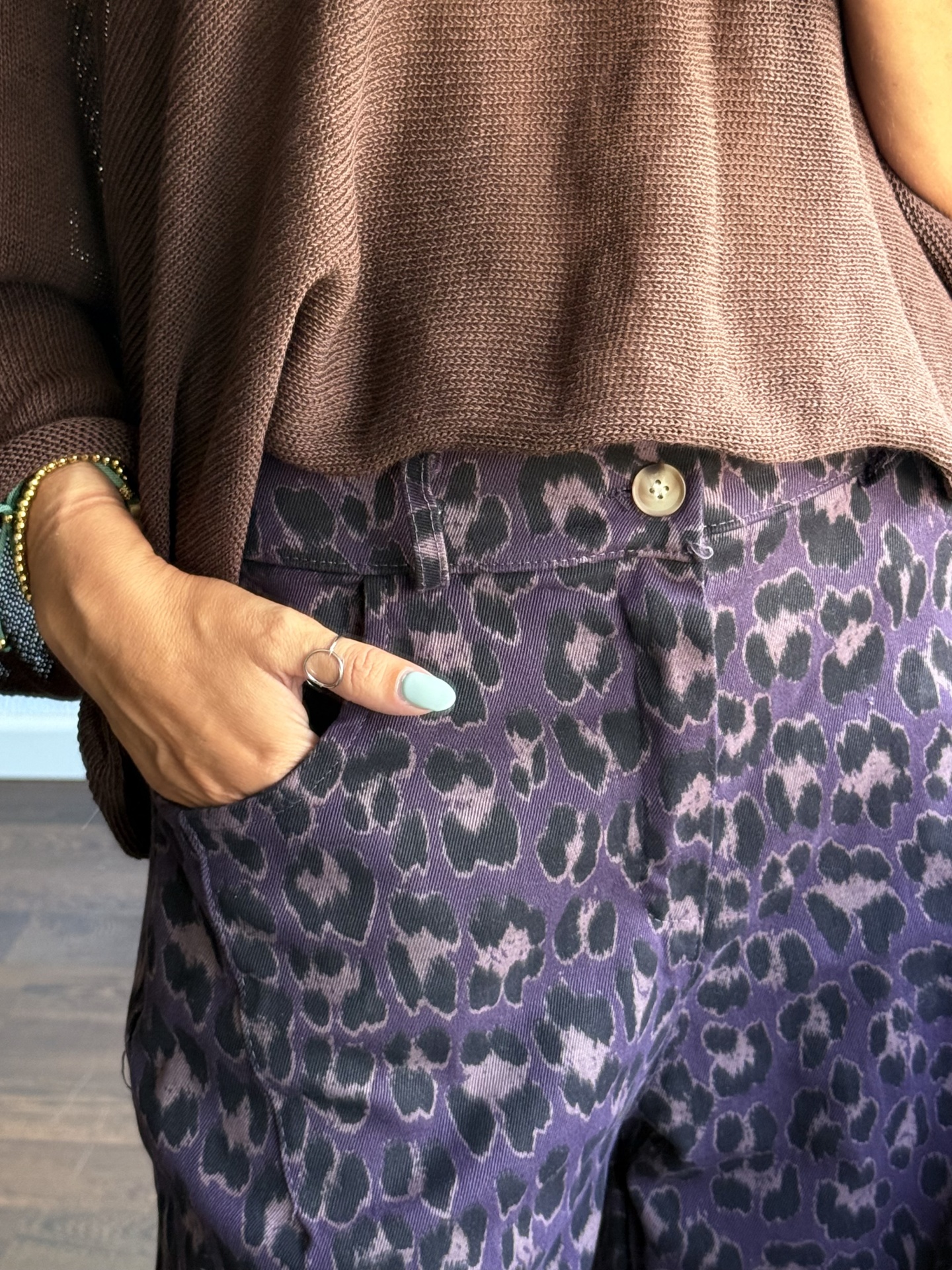 Calças com padrão de animal print roxo e preto e camisola castanha de malha