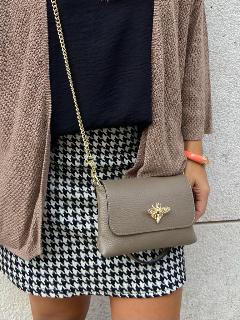 Mala castanha com fecho abelha dourada e alça de corrente, usada com falda pied-de-poule preto e branco e cardigã castanho.