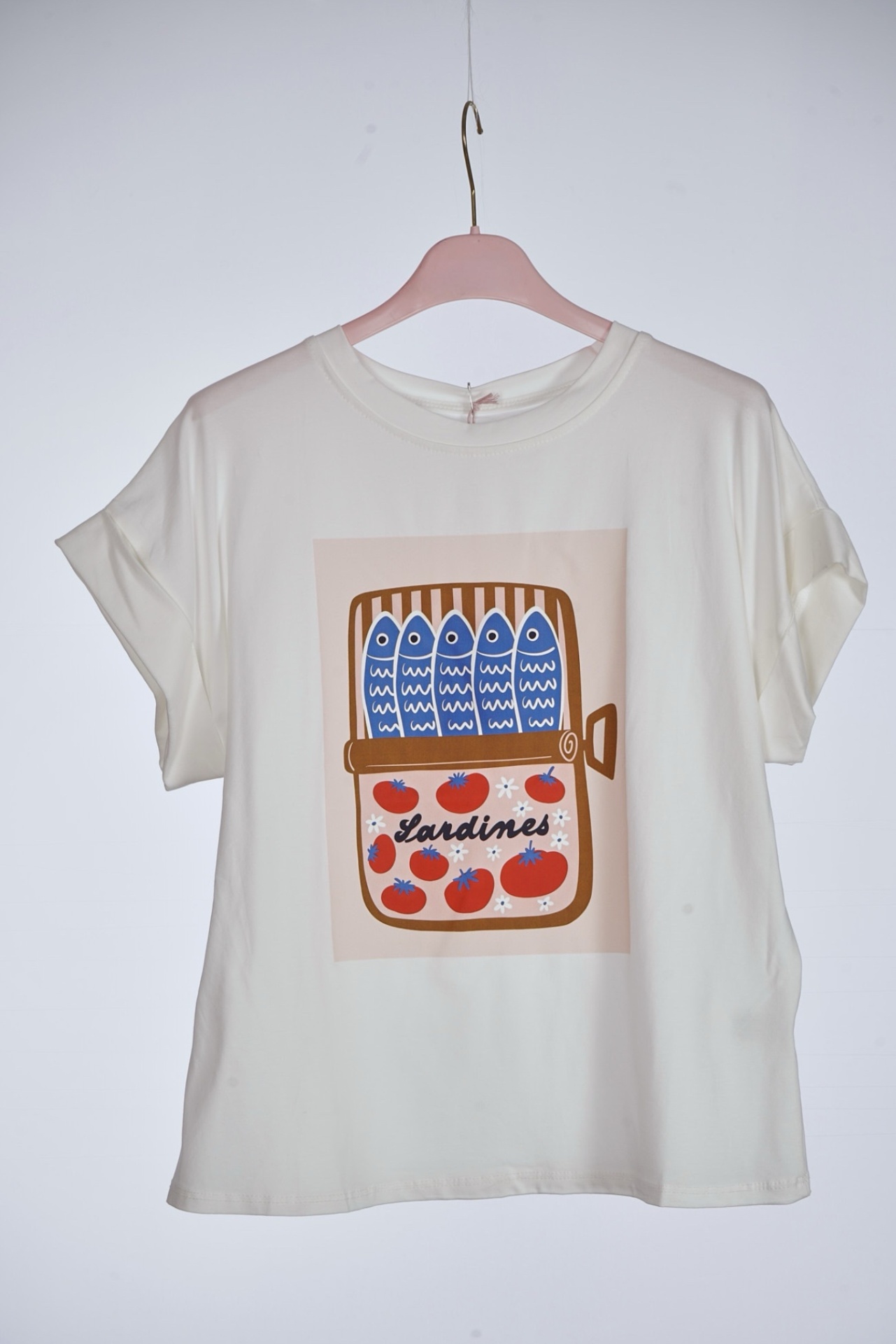 T-shirt branca com estampa de lata de sardinhas e tomates.
