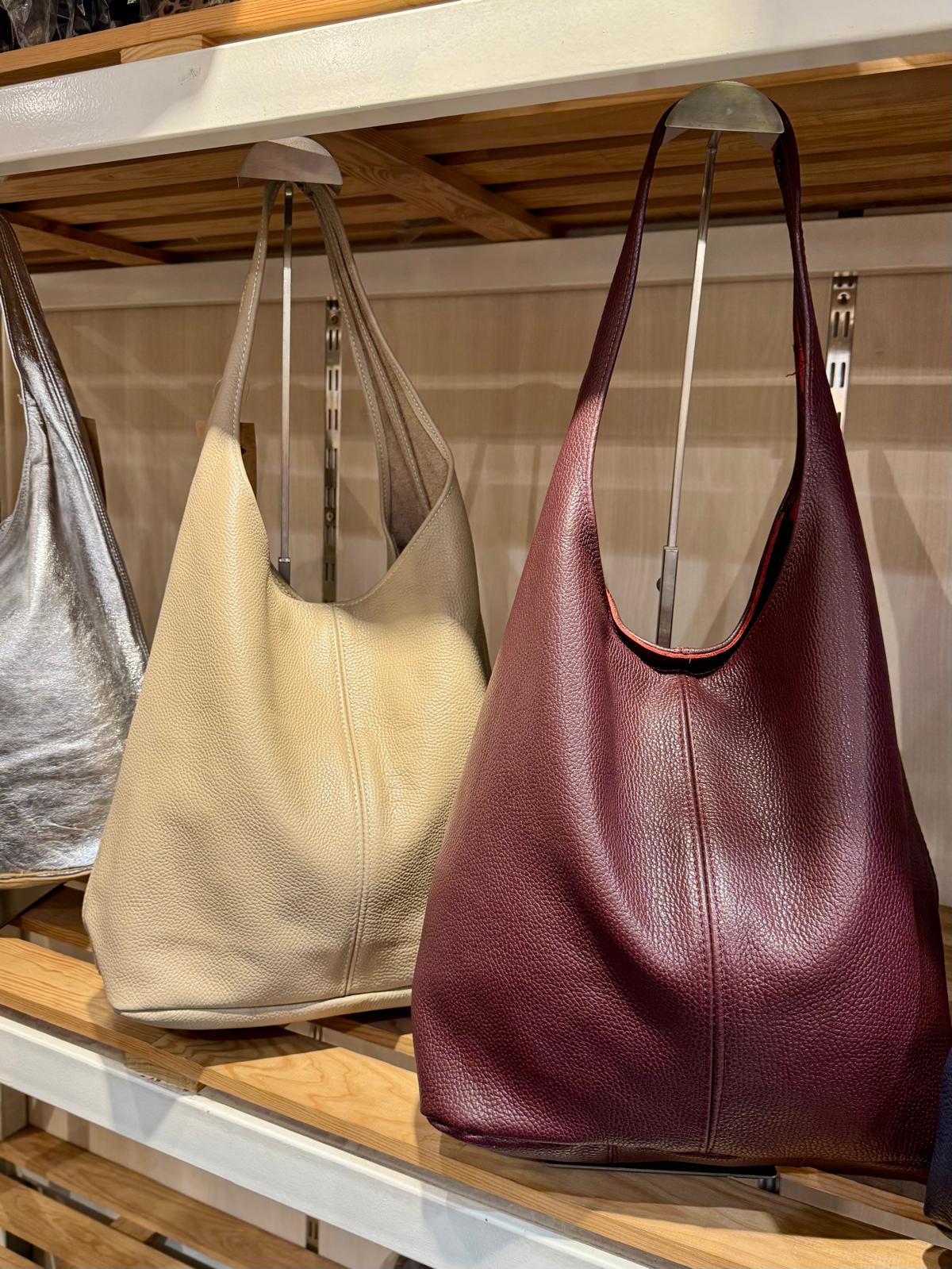 Bolsas grandes de ombro em prateleira, cores prateado, bege e vinho