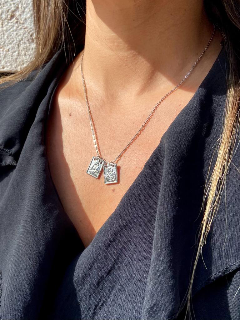 Colar prateado com duas placas retangulares usado ao pescoço