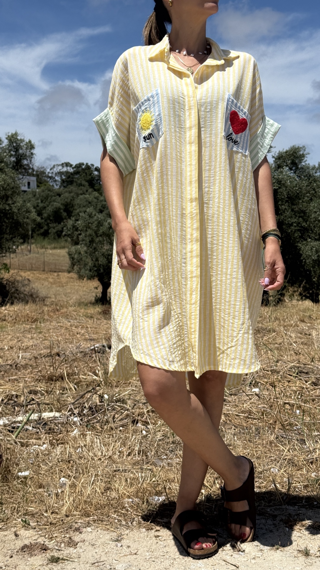Vestido amarelo às riscas com bolsos decorados em ambiente rural