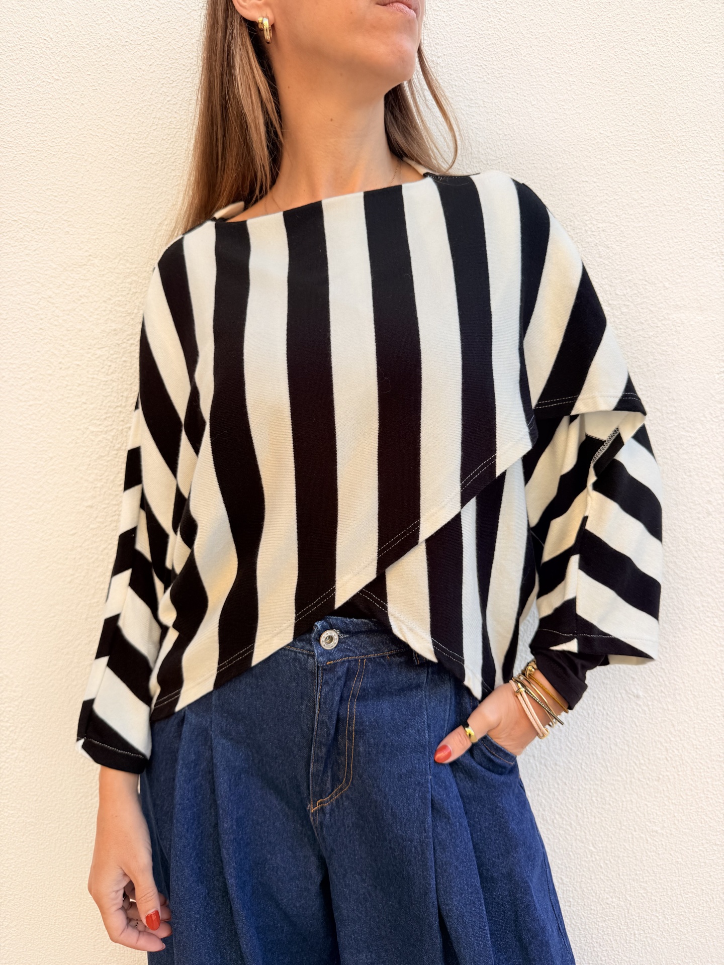 Blusa riscada preta e branca com calças de ganga azuis