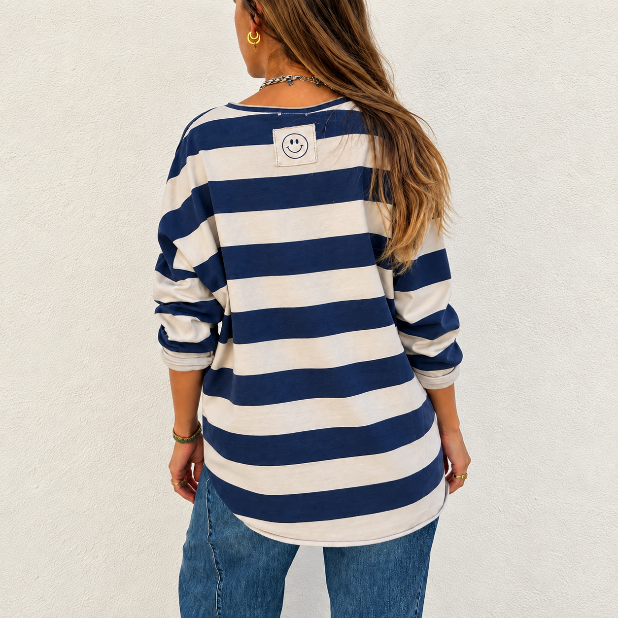 Camisola riscada azul e branca com etiqueta sorridente vista de costas