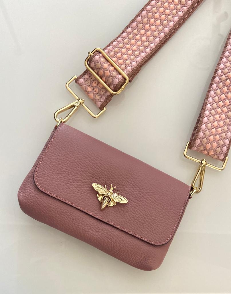 Mala pequena rosa em pele com abelha dourada e alça larga rosa com padrão geométrico