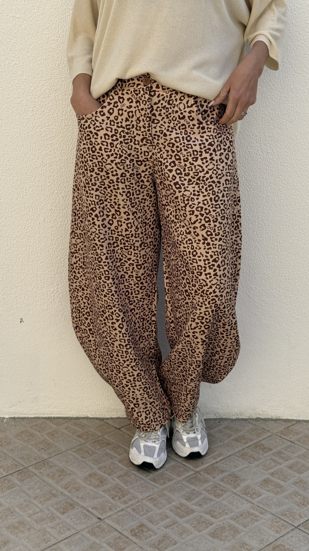 Calças largas padrão onça castanho e bege com sapatilhas brancas e cinzentas
