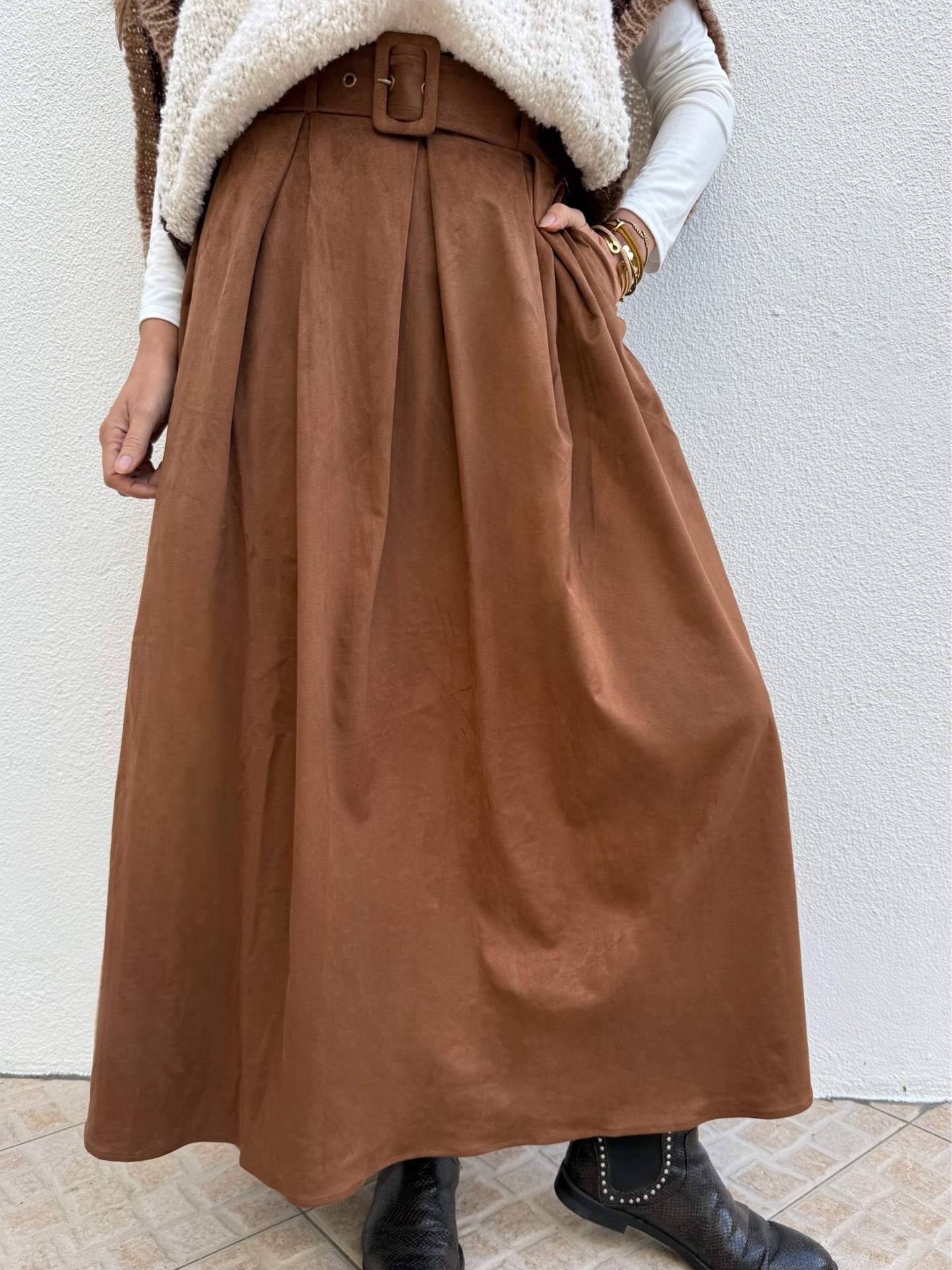 Saia comprida castanha com cinto largo e botas pretas
