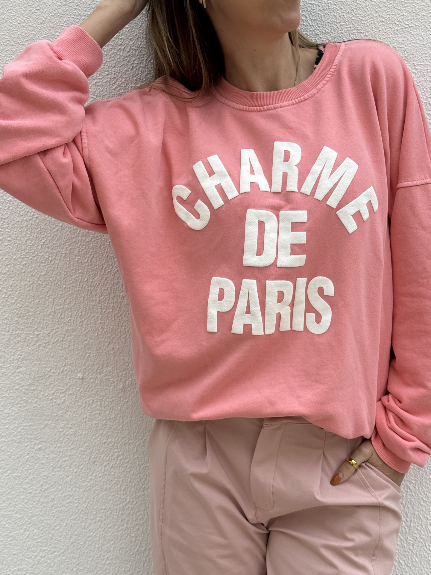 Sweatshirt rosa com texto branco e calças rosa claro em fundo branco