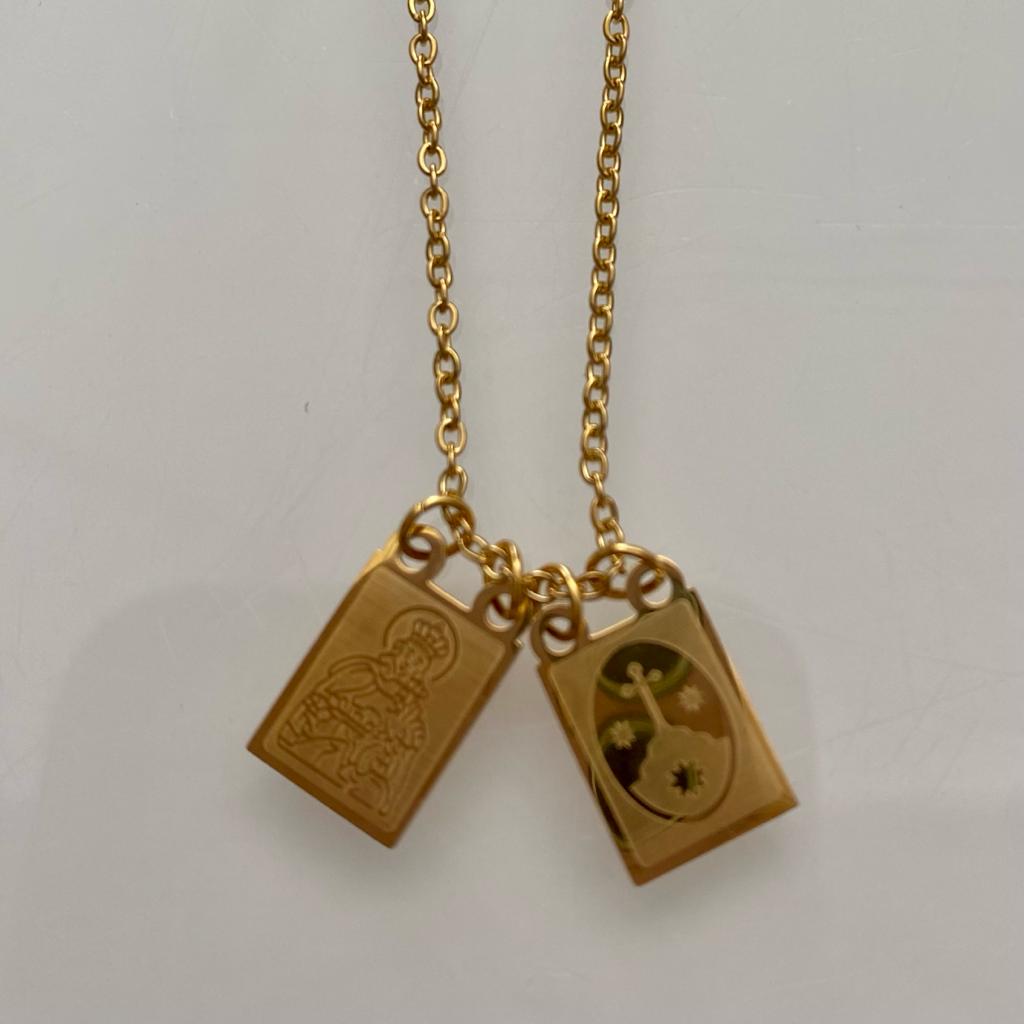 Colar dourado com dois pendentes retangulares, um com santo gravado e outro floral colorido