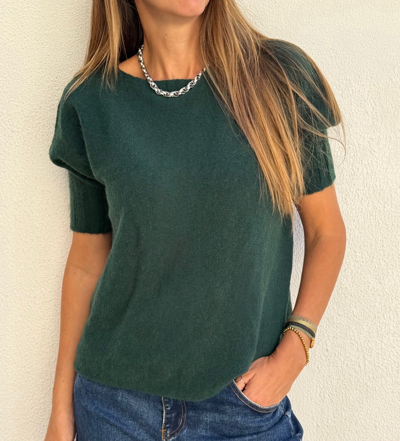 Camisola de malha verde escura com mangas curtas e jeans azul