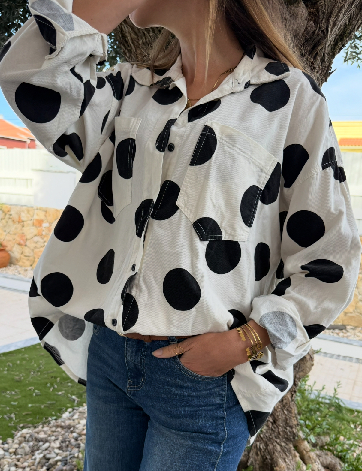 Camisa branca com bolinhas pretas e calças de ganga