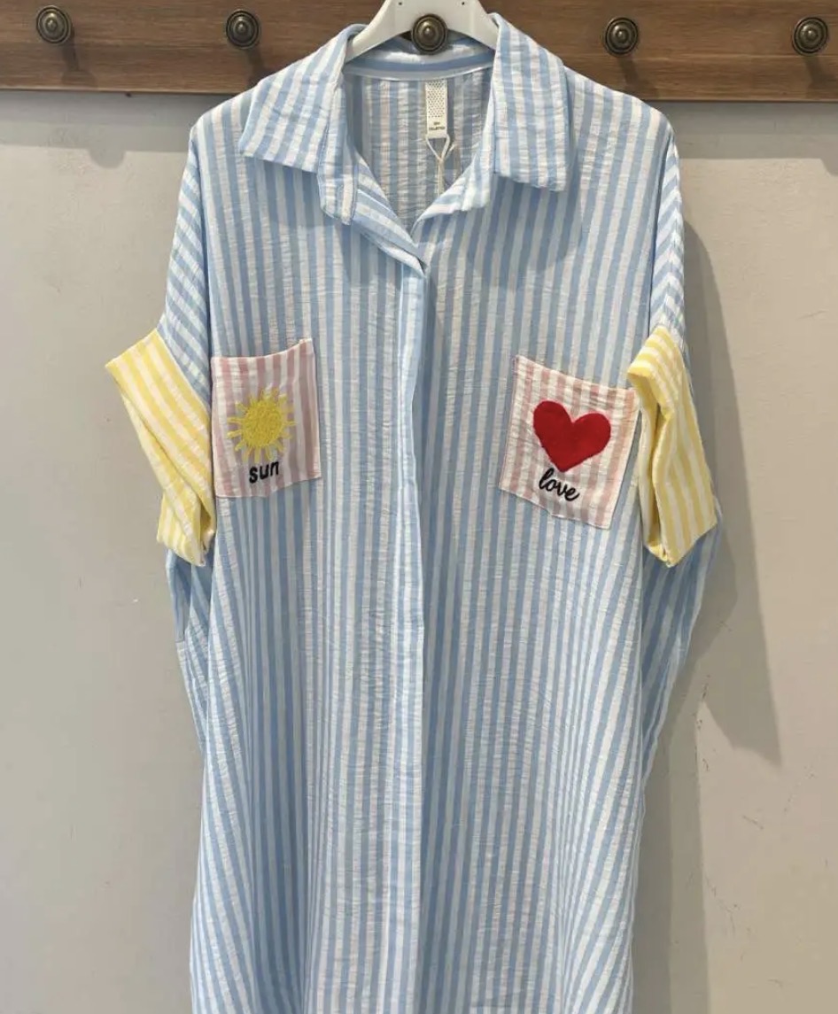 Vestido riscado azul claro e branco com bolsos decorados e mangas amarelas de riscas.