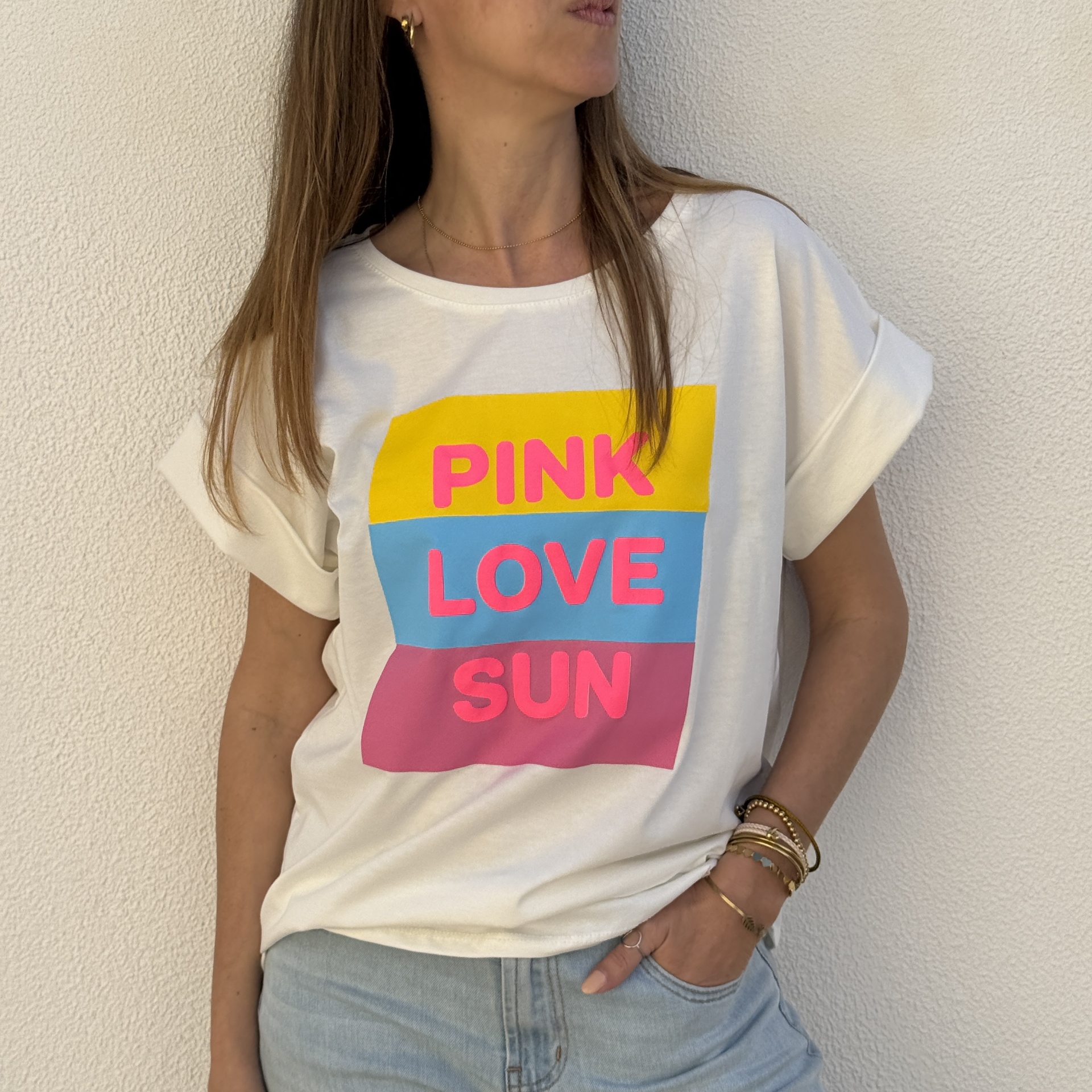 T-shirt branca com estampado colorido e palavras em rosa