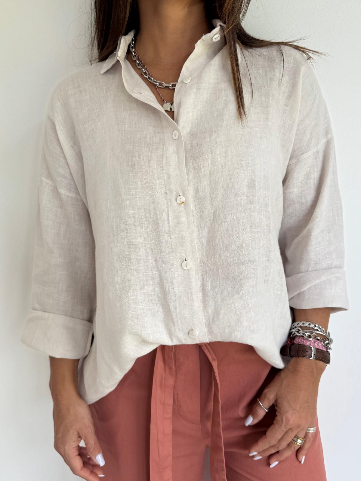 Camisa branca de linho com botões e calças cor de ferrugem.