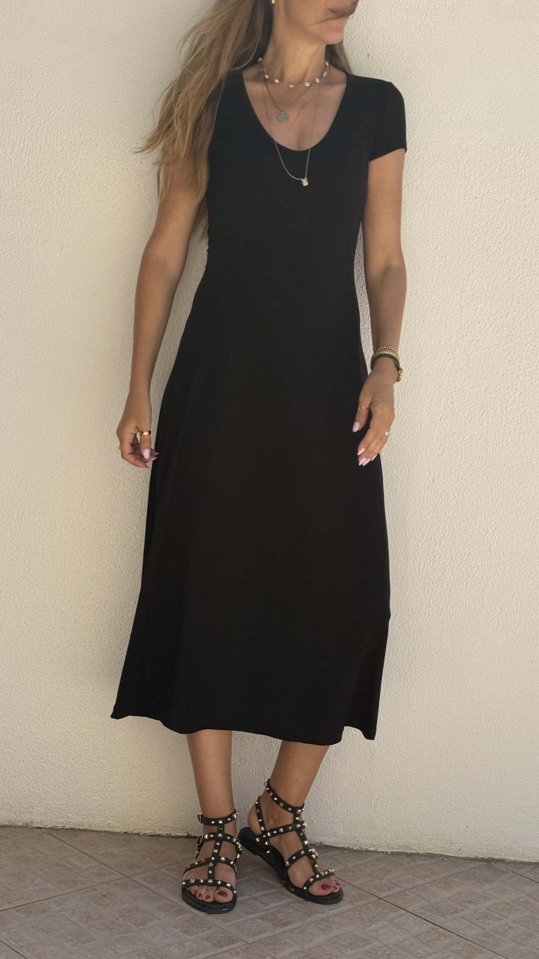 Vestido preto feminino de manga curta e sandálias pretas com tachas