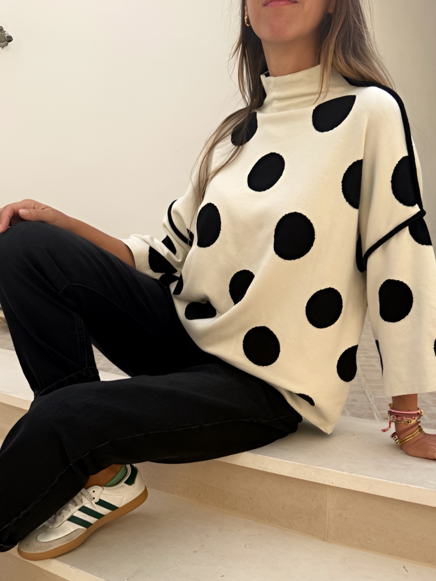 Camisola branca de malha com bolinhas pretas e calças pretas