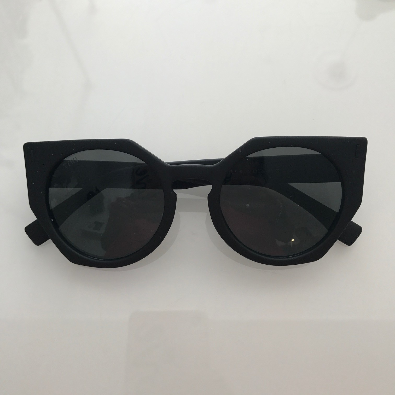 Óculos de sol com armação preta e lentes escuras