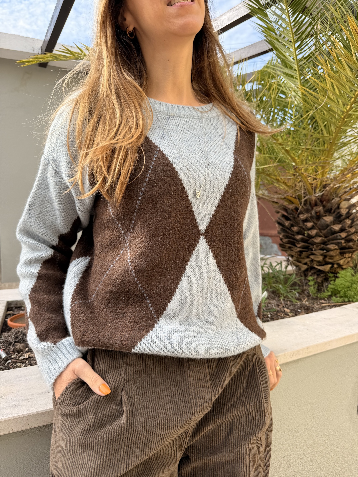 Camisola cinza clara com padrão xadrez castanho escuro e calças castanhas de veludo às riscas