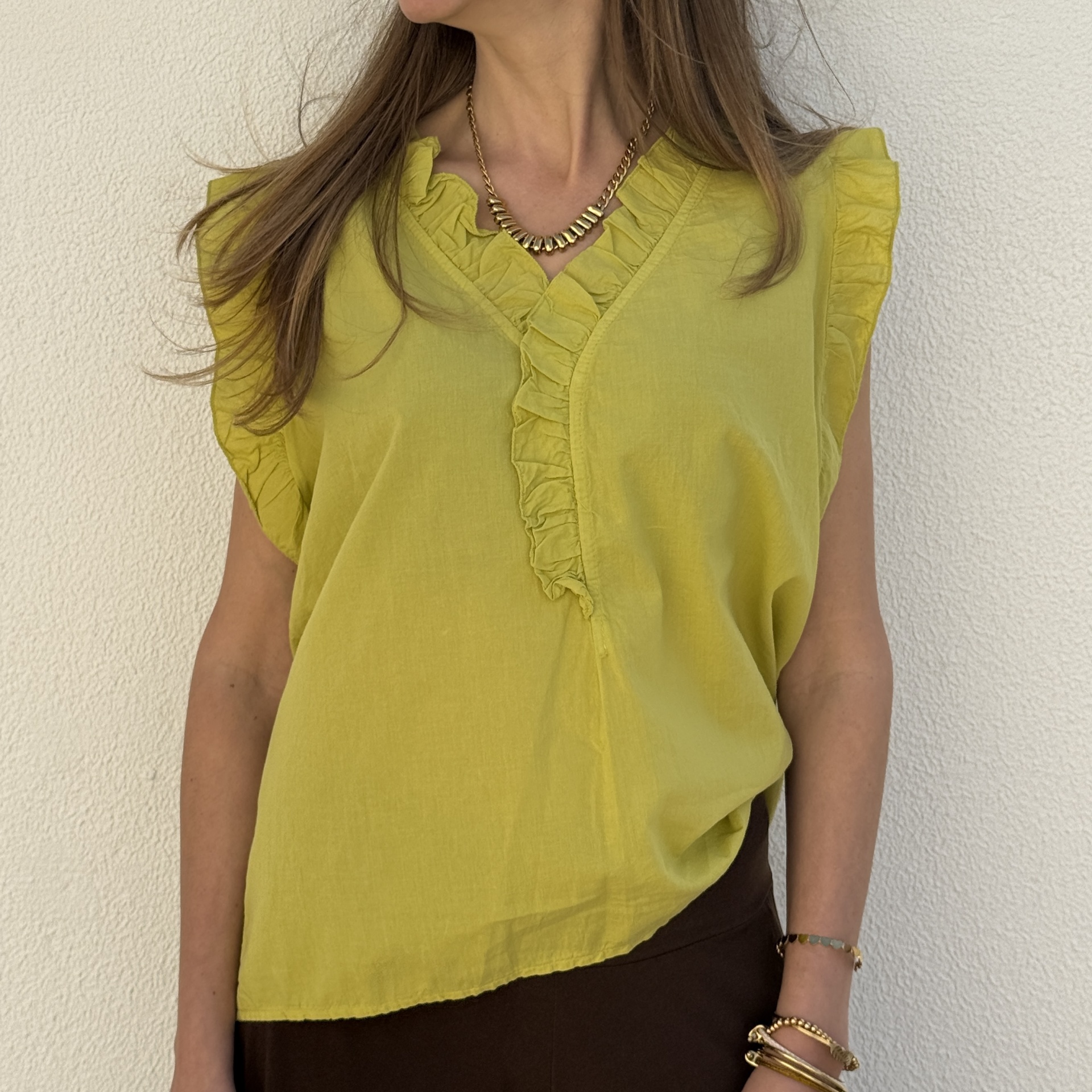 Blusa amarela com folhos no decote e mangas em fundo branco