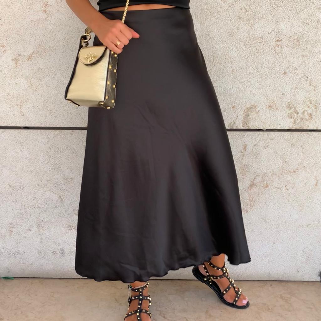 Saia longa preta com sandálias pretas com tachas e mala preta e bege