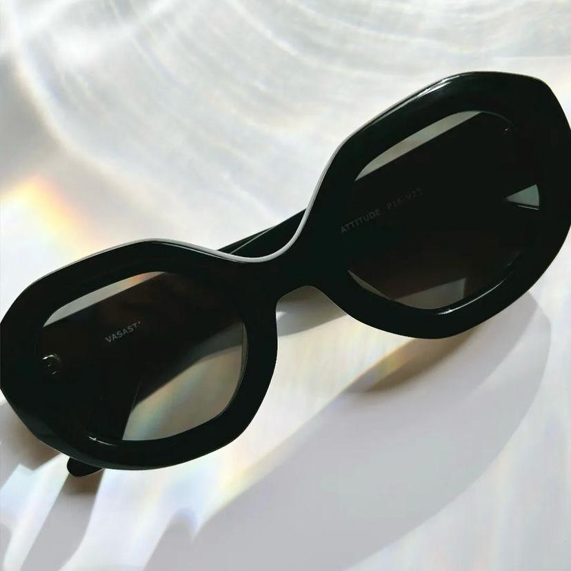 Óculos de sol pretos com armação grossa e lentes escuras sobre fundo branco