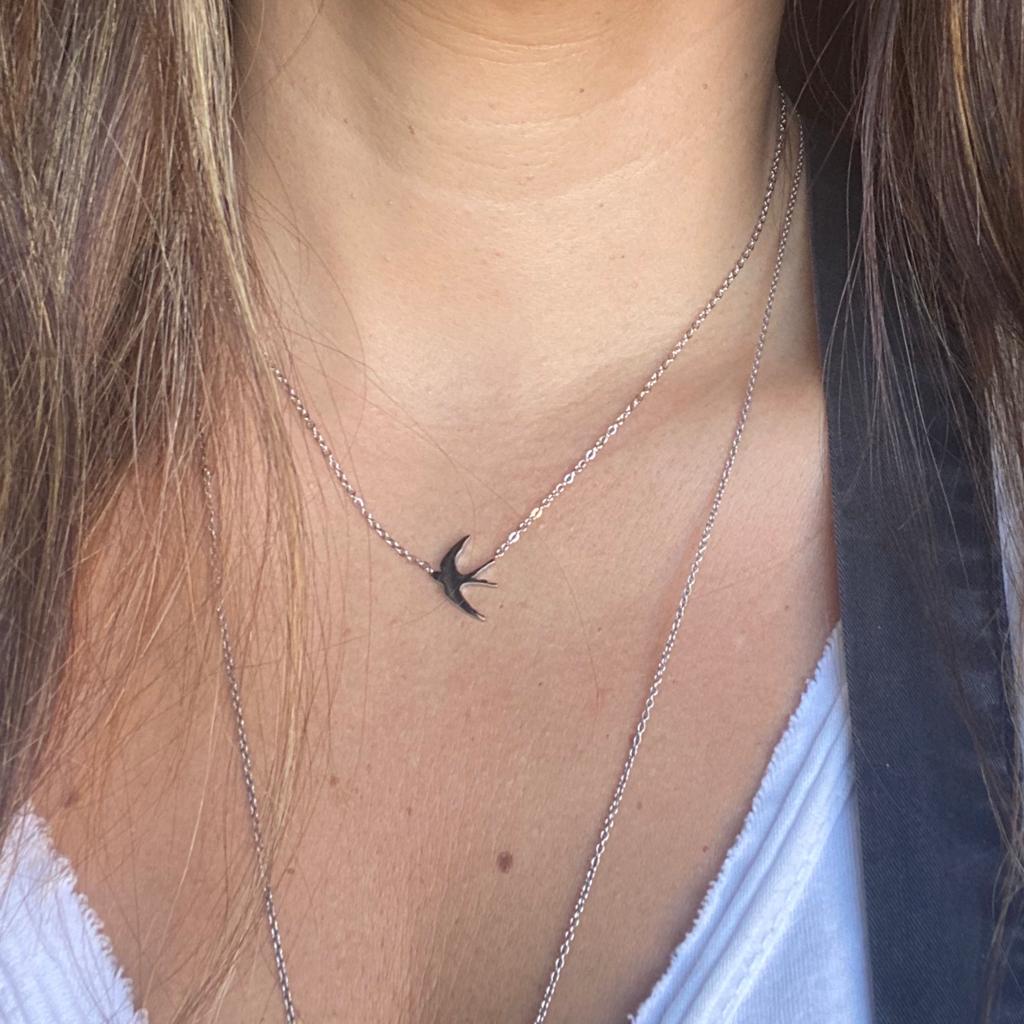 Colar com pendente de andorinha preta numa corrente prateada
