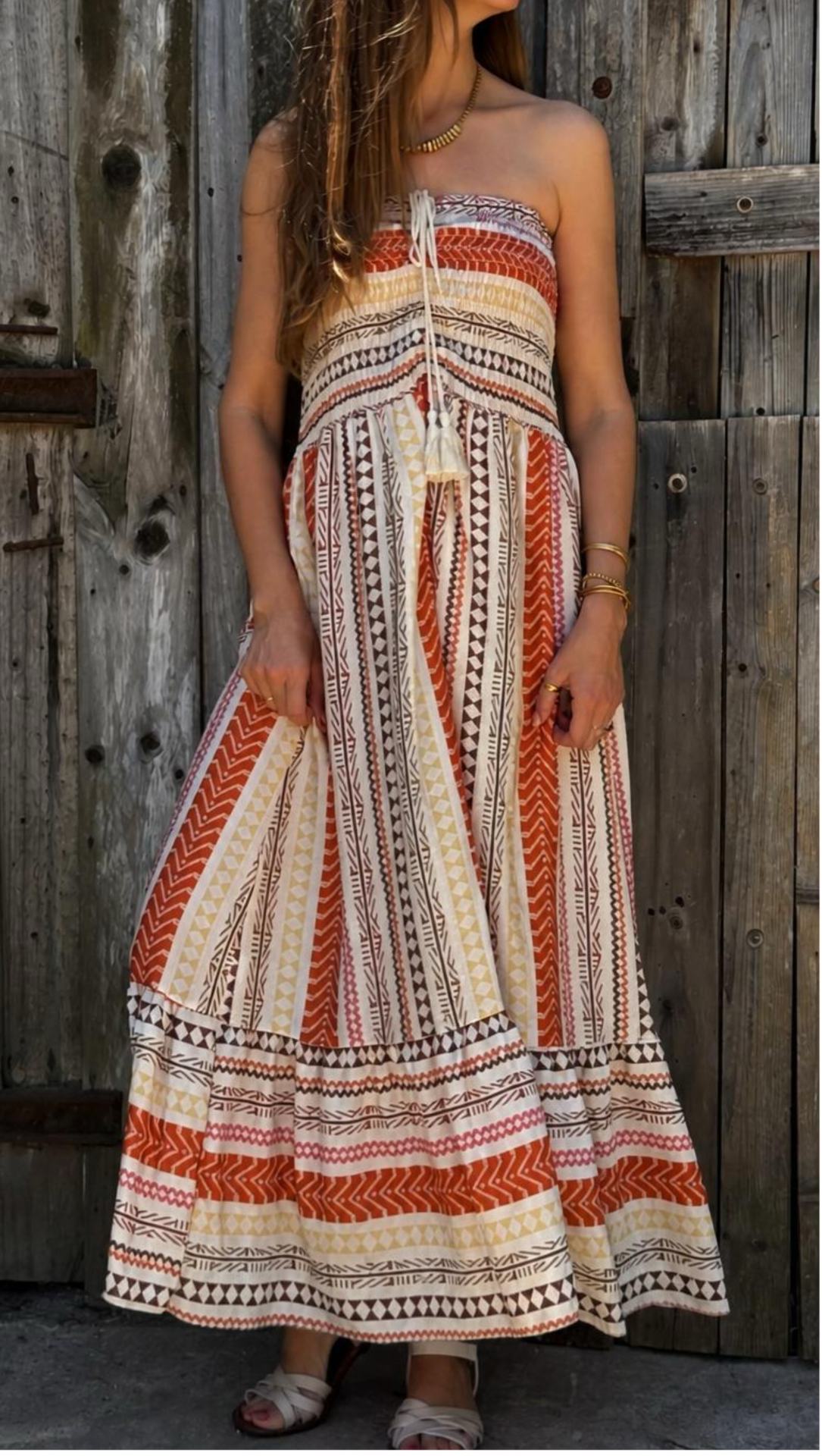 Vestido longo tomara que caia com padrão geométrico colorido.