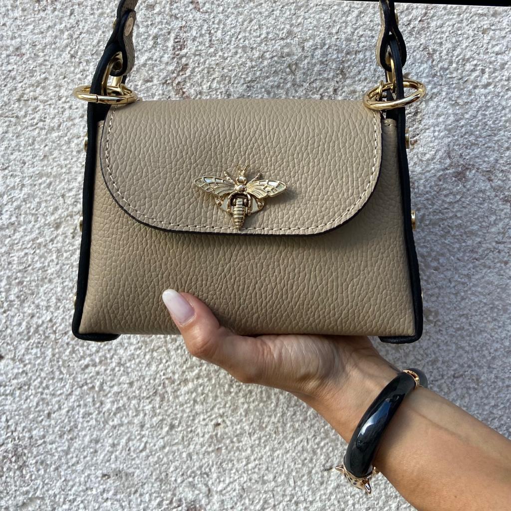 Mala pequena bege com abelha dourada e tiras pretas