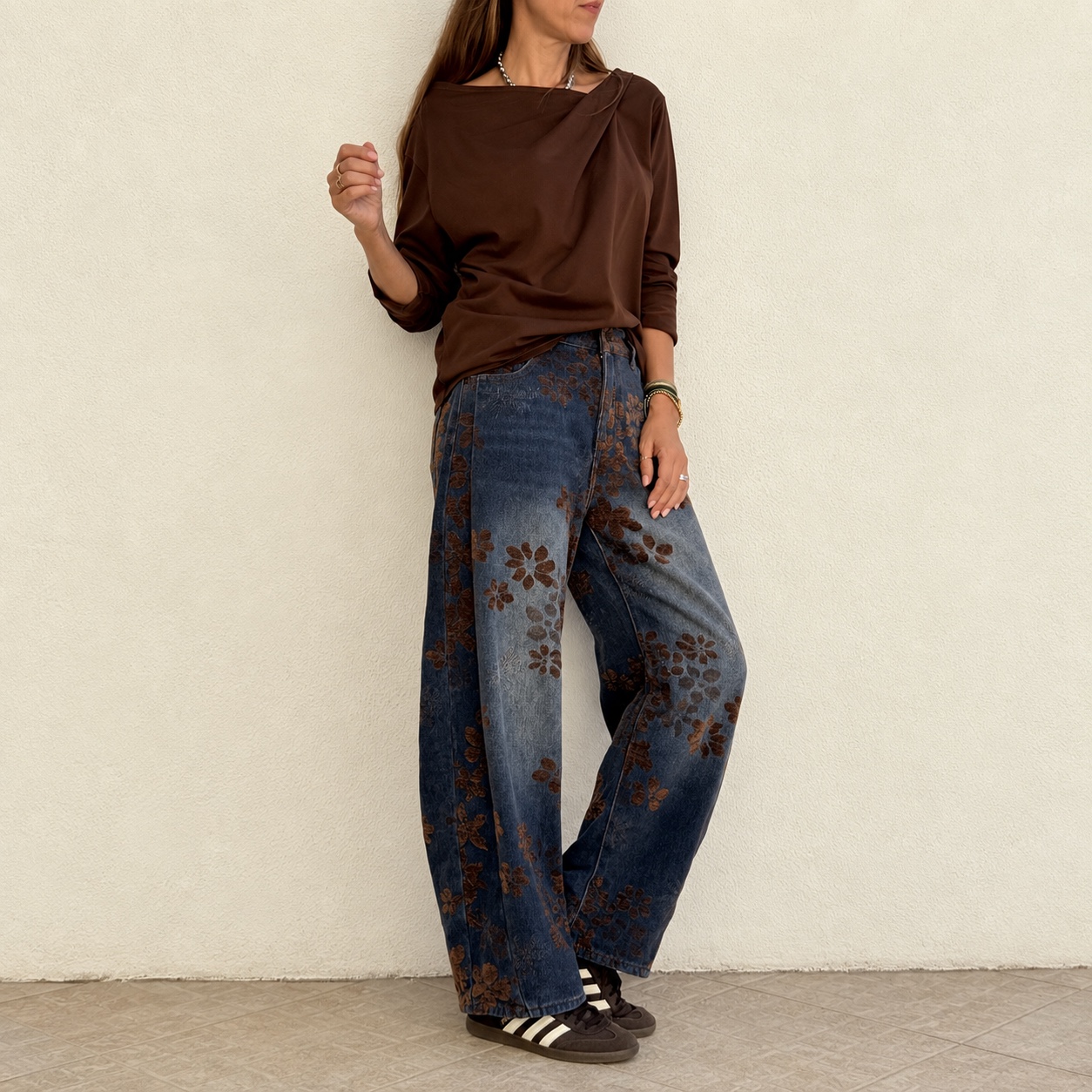 Calças de ganga largas com padrão floral e camisola castanha de manga comprida