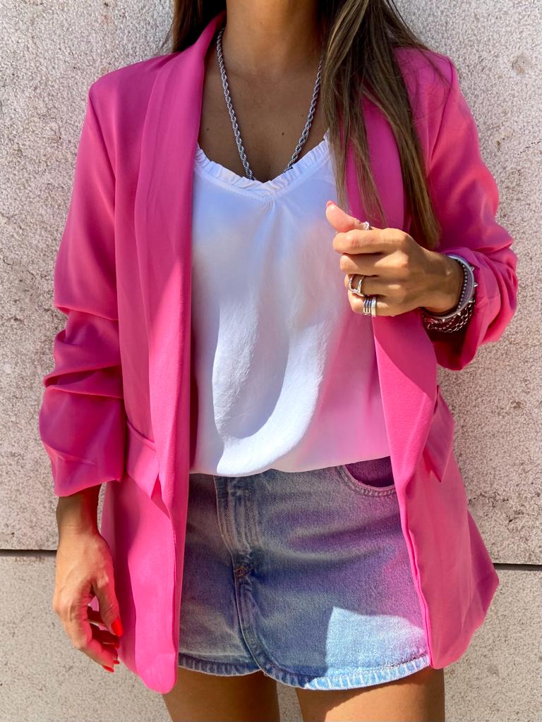 Blazer feminino rosa sobre blusa branca e saia jeans azul clara