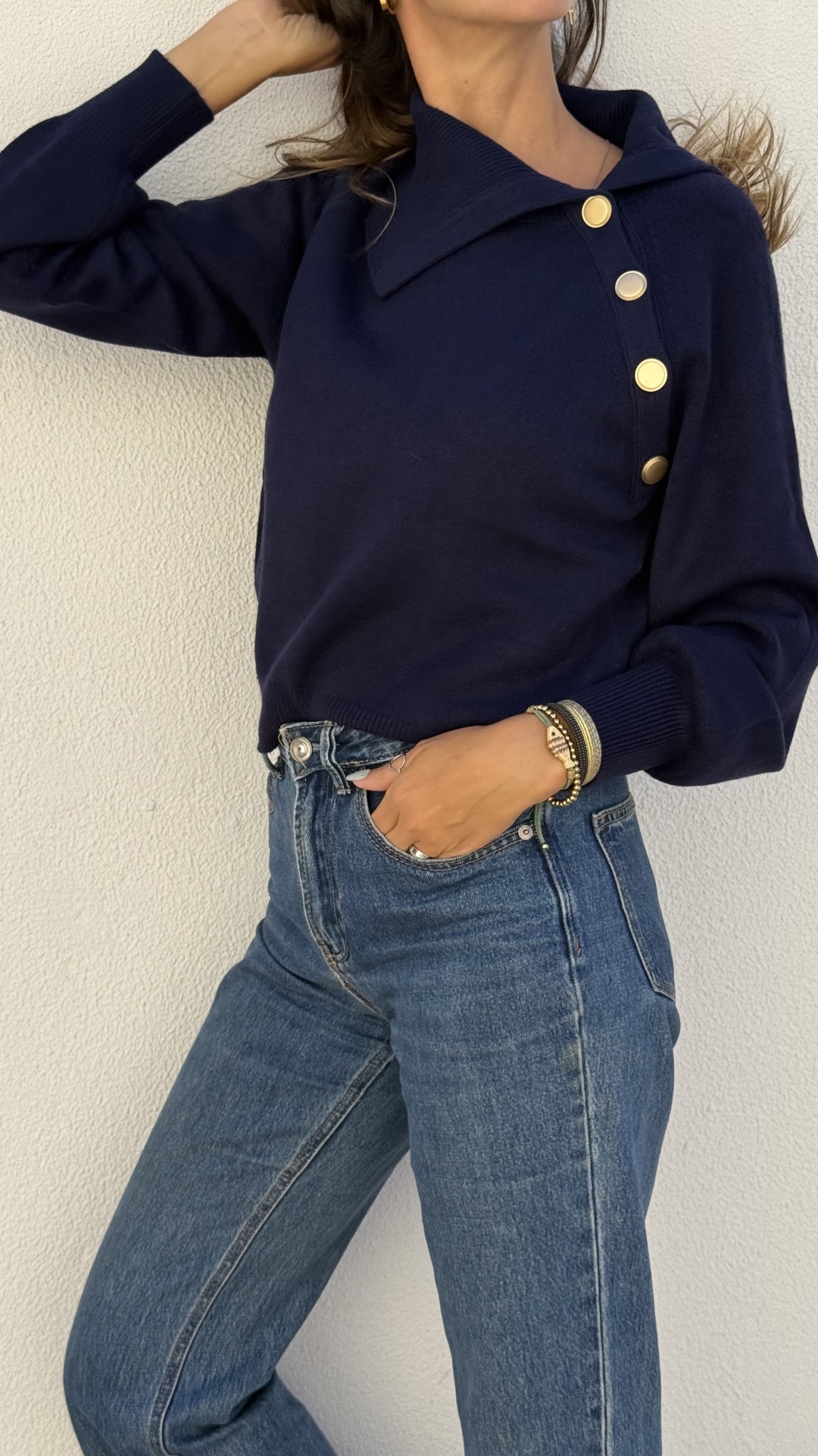 Camisola azul escura com botões dourados e jeans azuis