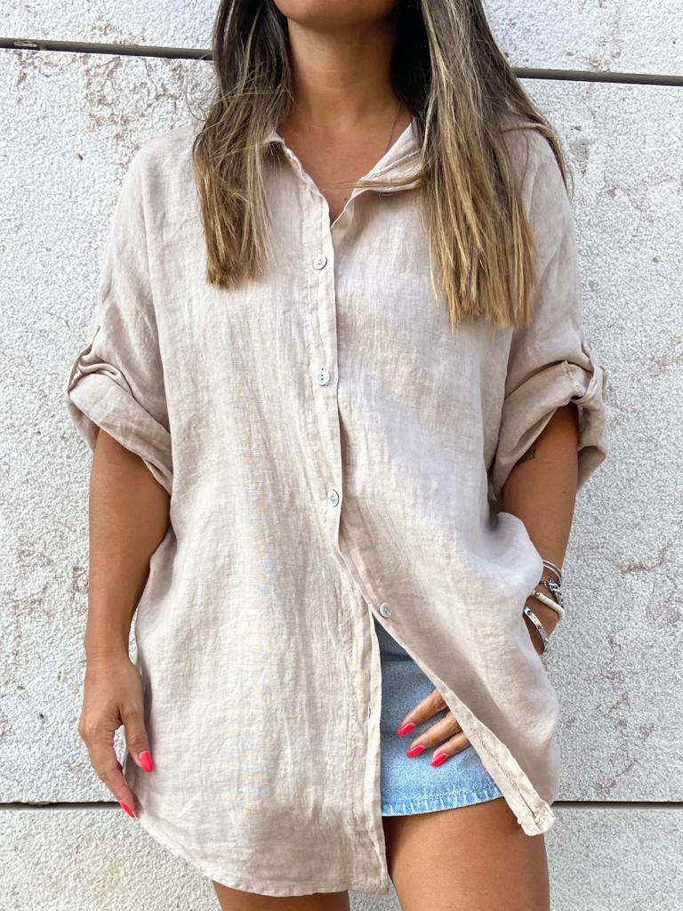 Camisa bege de linho feminina com botões e mangas dobradas, usada com peça inferior de ganga
