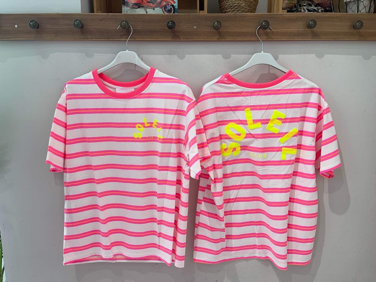 Duas t-shirts às riscas rosa, branco e laranja com texto amarelo SOLCELL CLUB