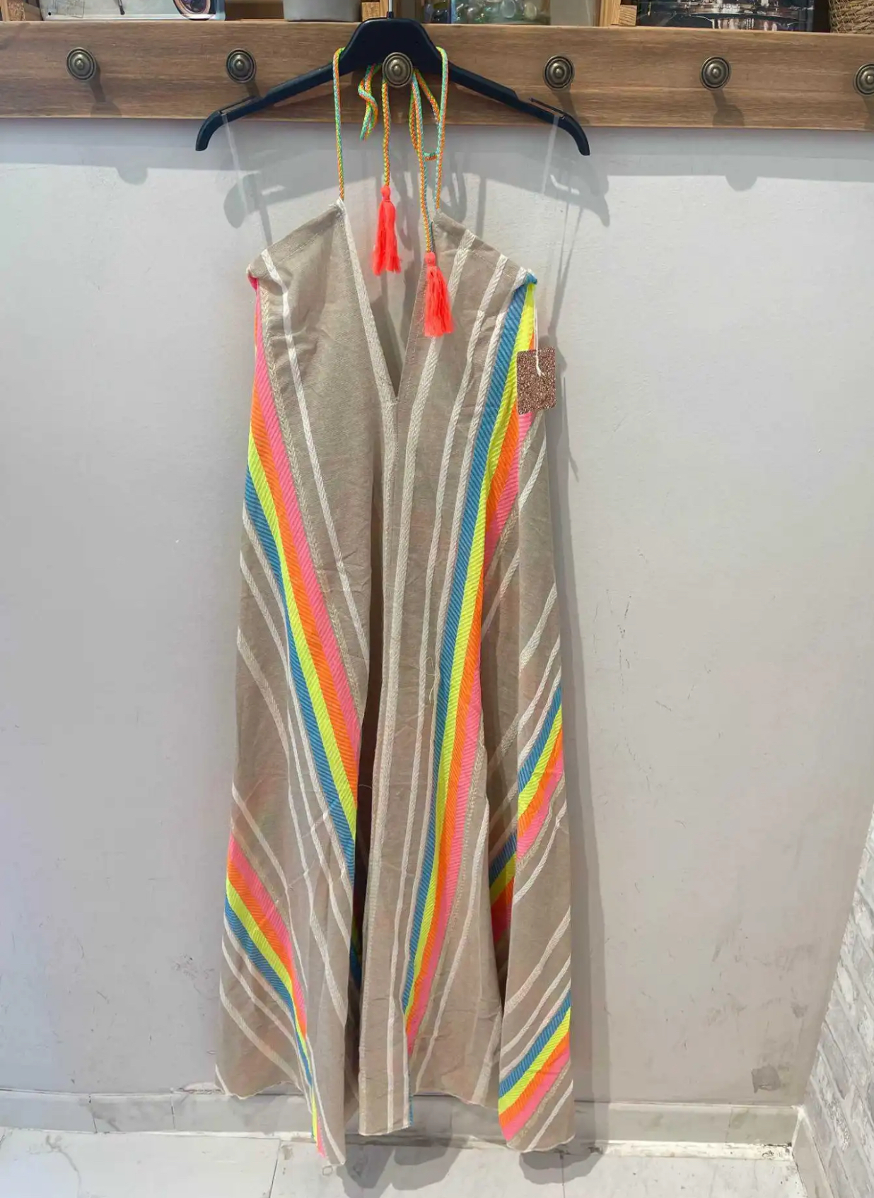 Vestido comprido com riscas coloridas pendurado em cabide
