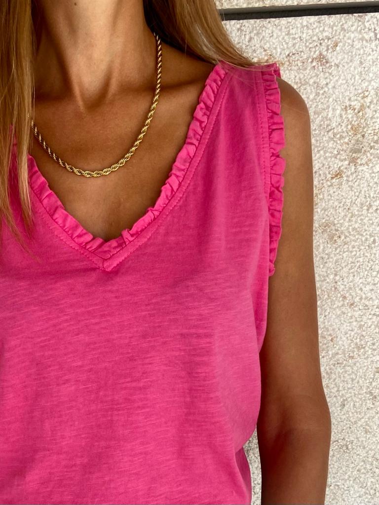Top cor-de-rosa com decote em V e borda franzida, colar dourado, fundo branco