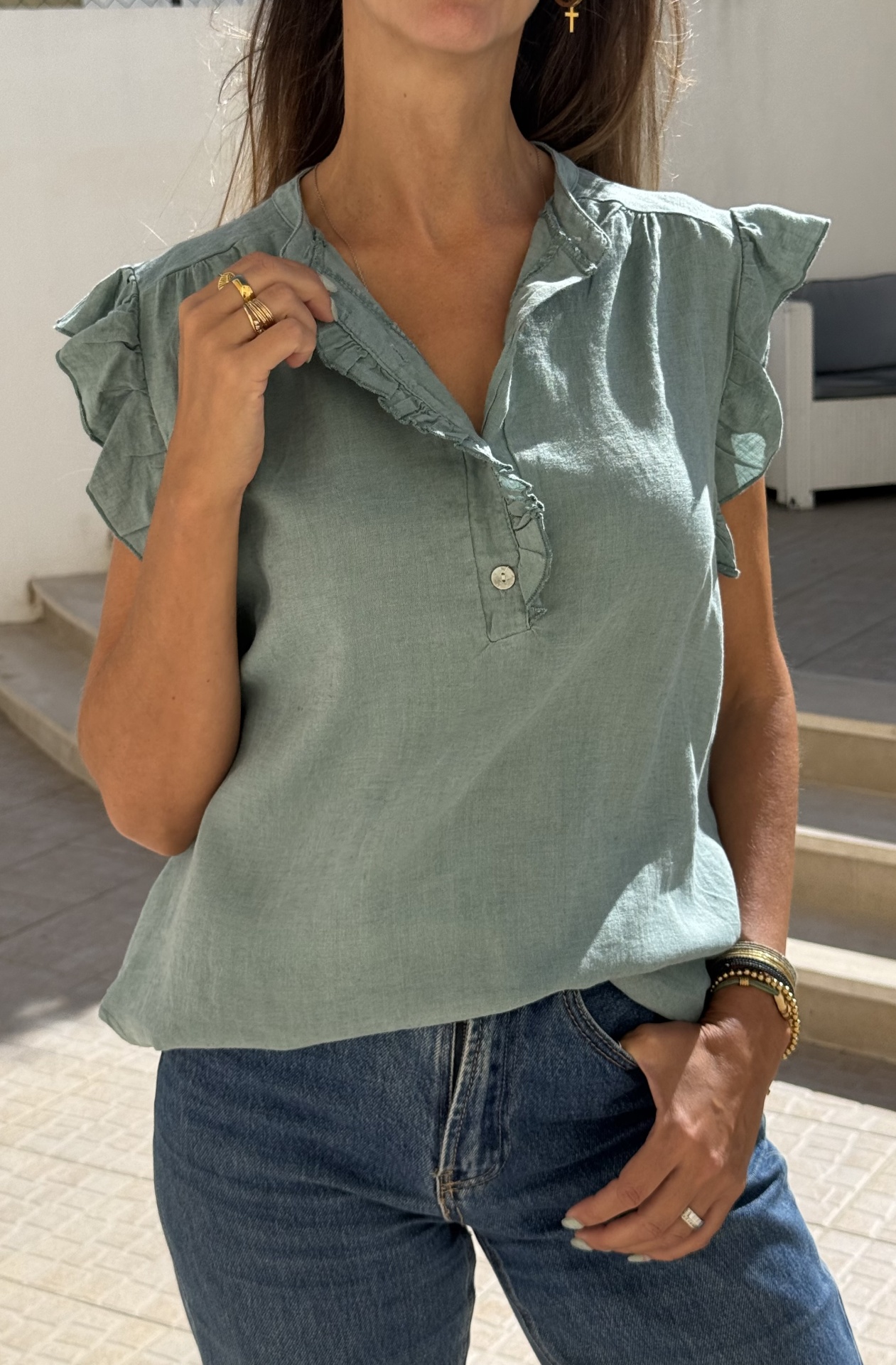 Blusa verde água manga curta com franzidos e botões frontais combinada com jeans azul escuro
