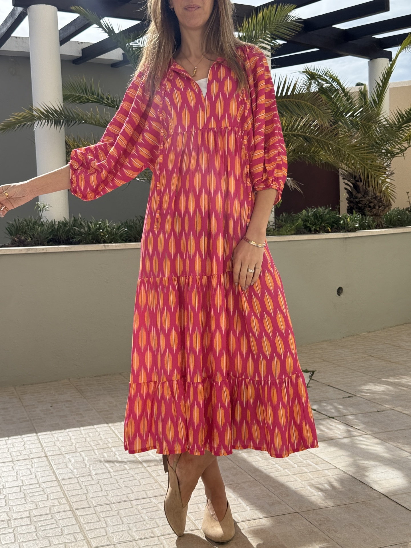 Vestido comprido colorido com padrão geométrico usado ao ar livre.