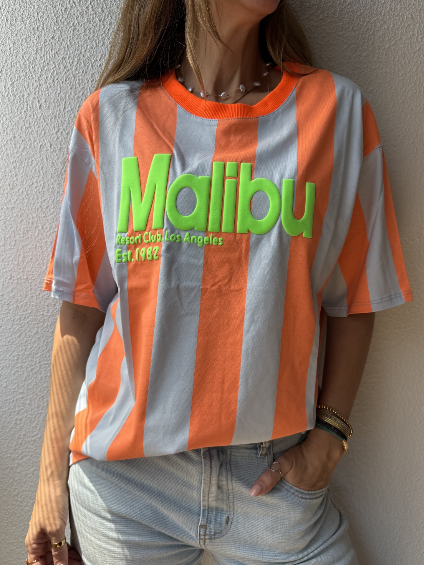 T-shirt riscada laranja e cinza com texto verde em relevo Malibu