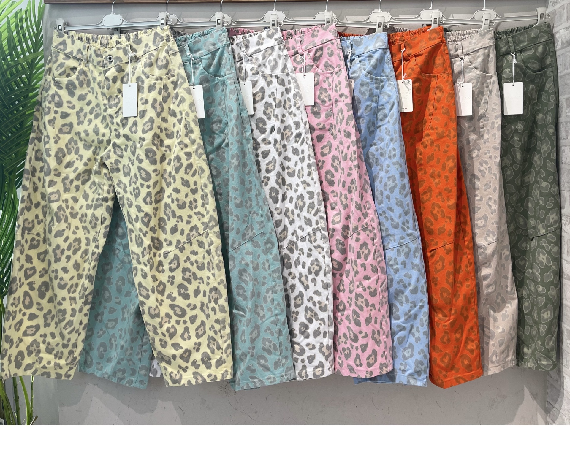 Calças com padrão animal print em várias cores penduradas em cabides