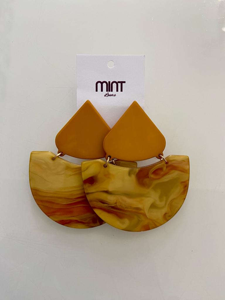 Brincos marmoreados castanhos e amarelos da marca MINT com cartão branco.