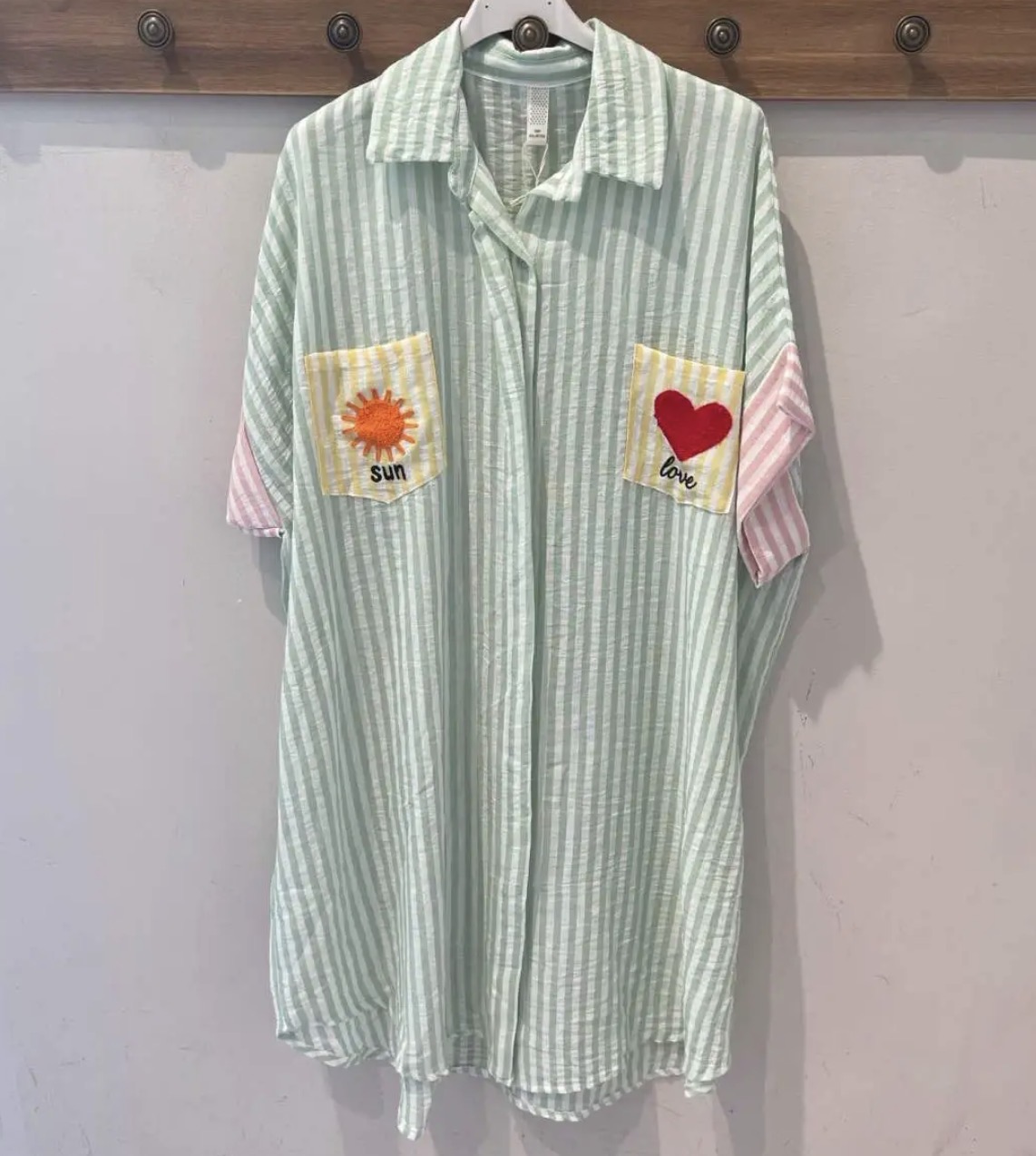 Camisa riscada verde e branca com bolsos amarelos e apliques de sol e coração