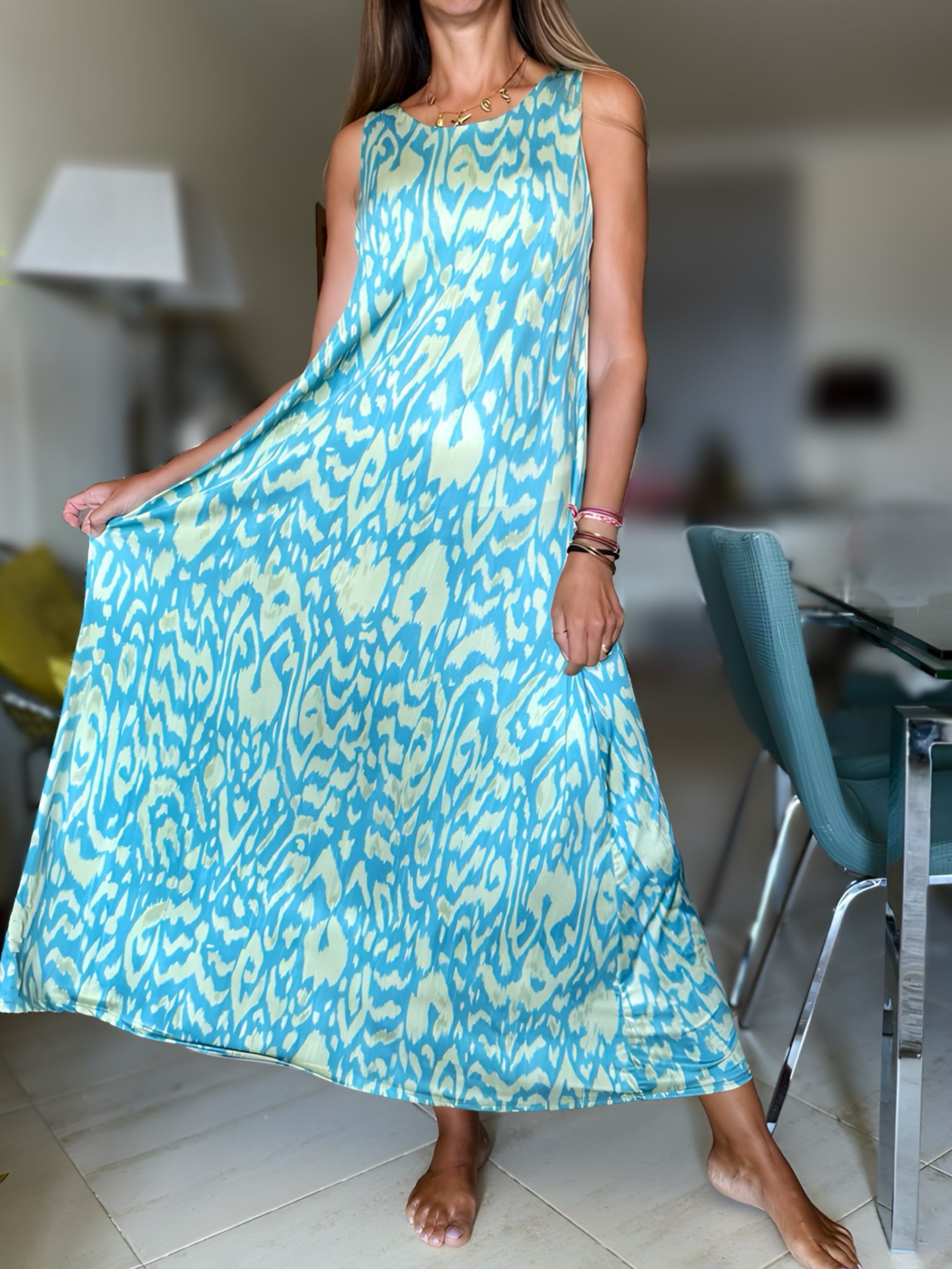 Vestido longo azul e creme com padrão abstrato usado por pessoa em ambiente interior