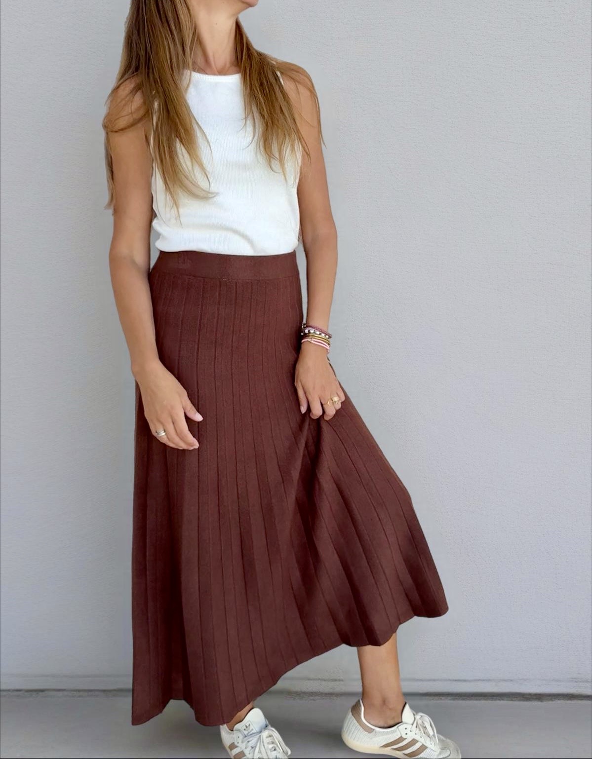 Saia longa castanha com riscas verticais e camisola branca de alças com ténis brancos