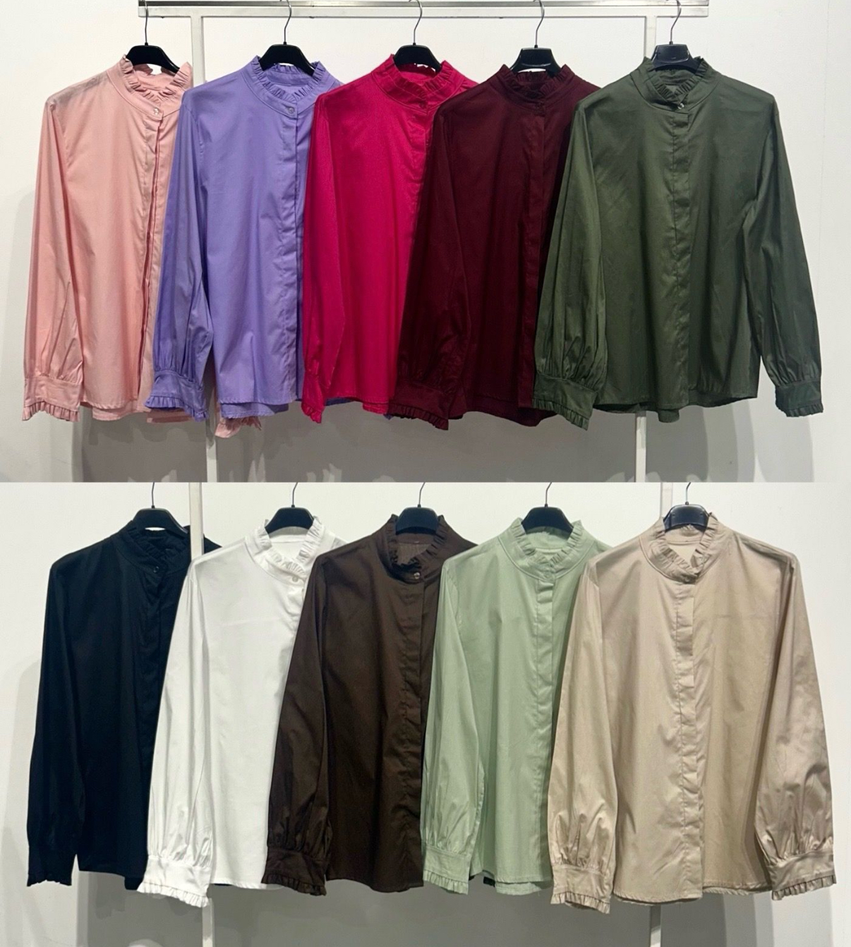 Dez blusas de manga comprida em várias cores penduradas em cabides