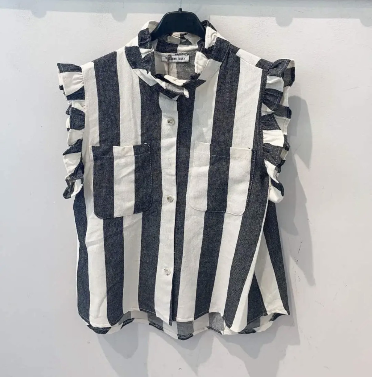 Camisa feminina sem mangas listrada em branco e preto com bolsos e folhos nas mangas.