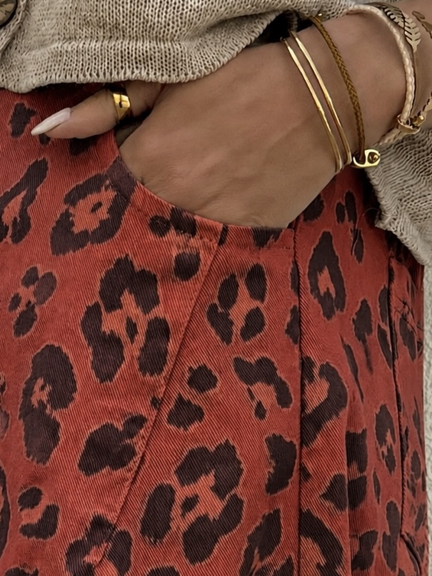 Saia vermelha com padrão de leopardo e acessórios dourados
