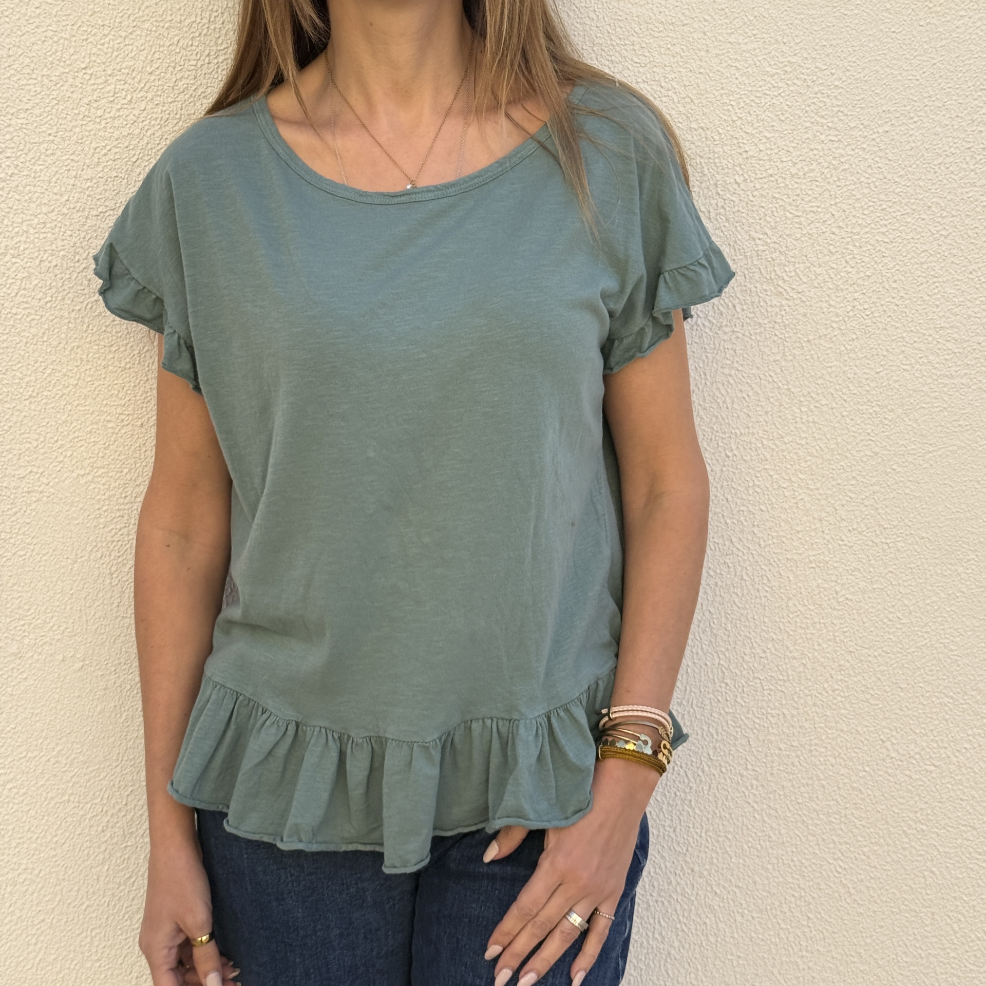 T-shirt verde água com folhos nas mangas e bainha usada por mulher.