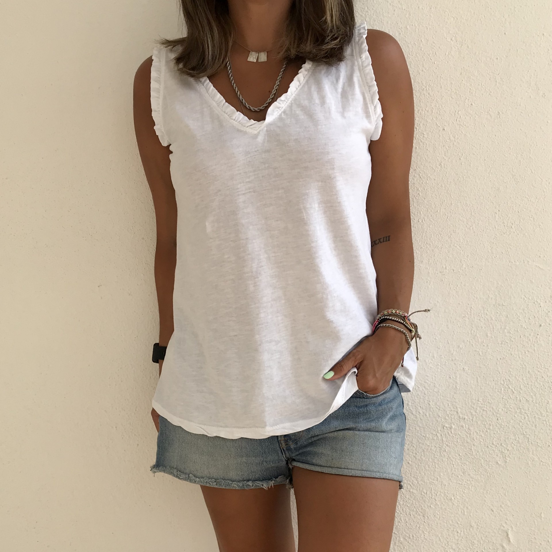 Camisola branca sem mangas com gola V e calções de ganga
