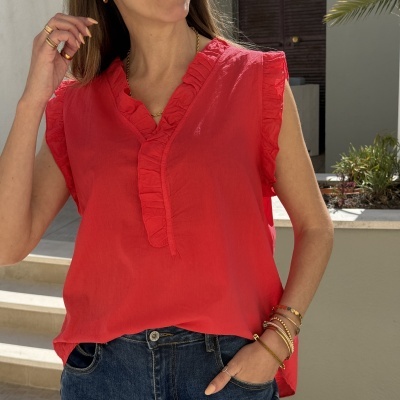 Blusa vermelha sem mangas com folhos e jeans azul