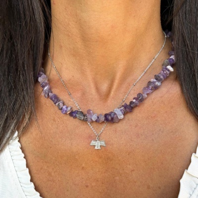 Colar duplo com pedras roxas e pendente de pássaro prateado ao pescoço